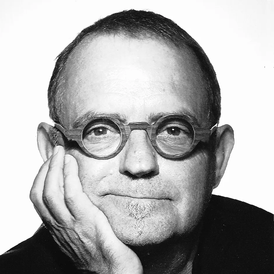 Portrait professionnel de Frédéric Buisson, expert en bioénergétique et géobiologie, souriant avec des lunettes rondes